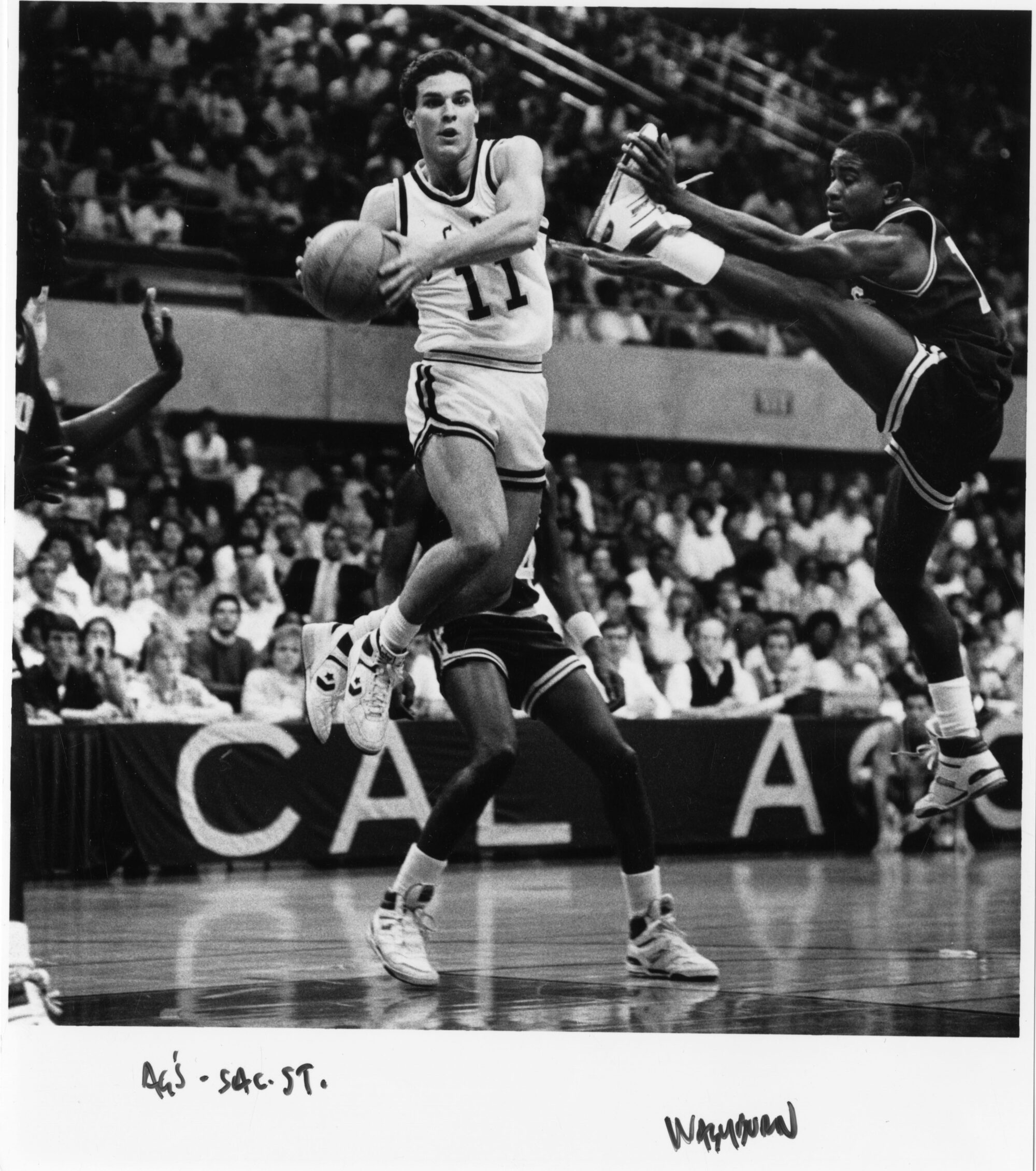 Mark Washburn holding a ball with other players trying to block him