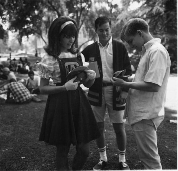 Orientation Week, student receives a freshman dink from a cheerleader, 1967 October.