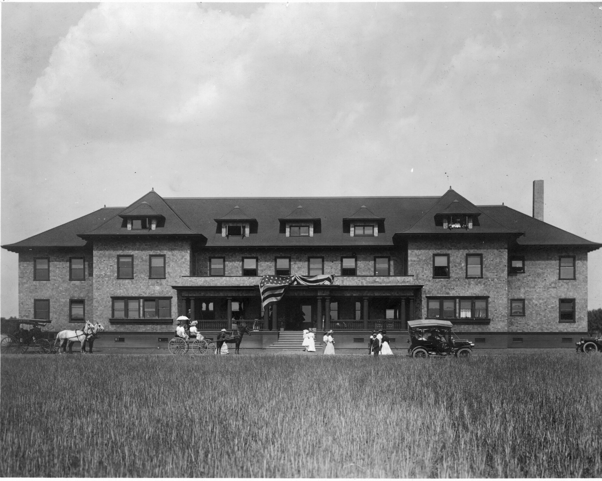 Horses and buggies parked outside of a North and South Hall dormitory building
