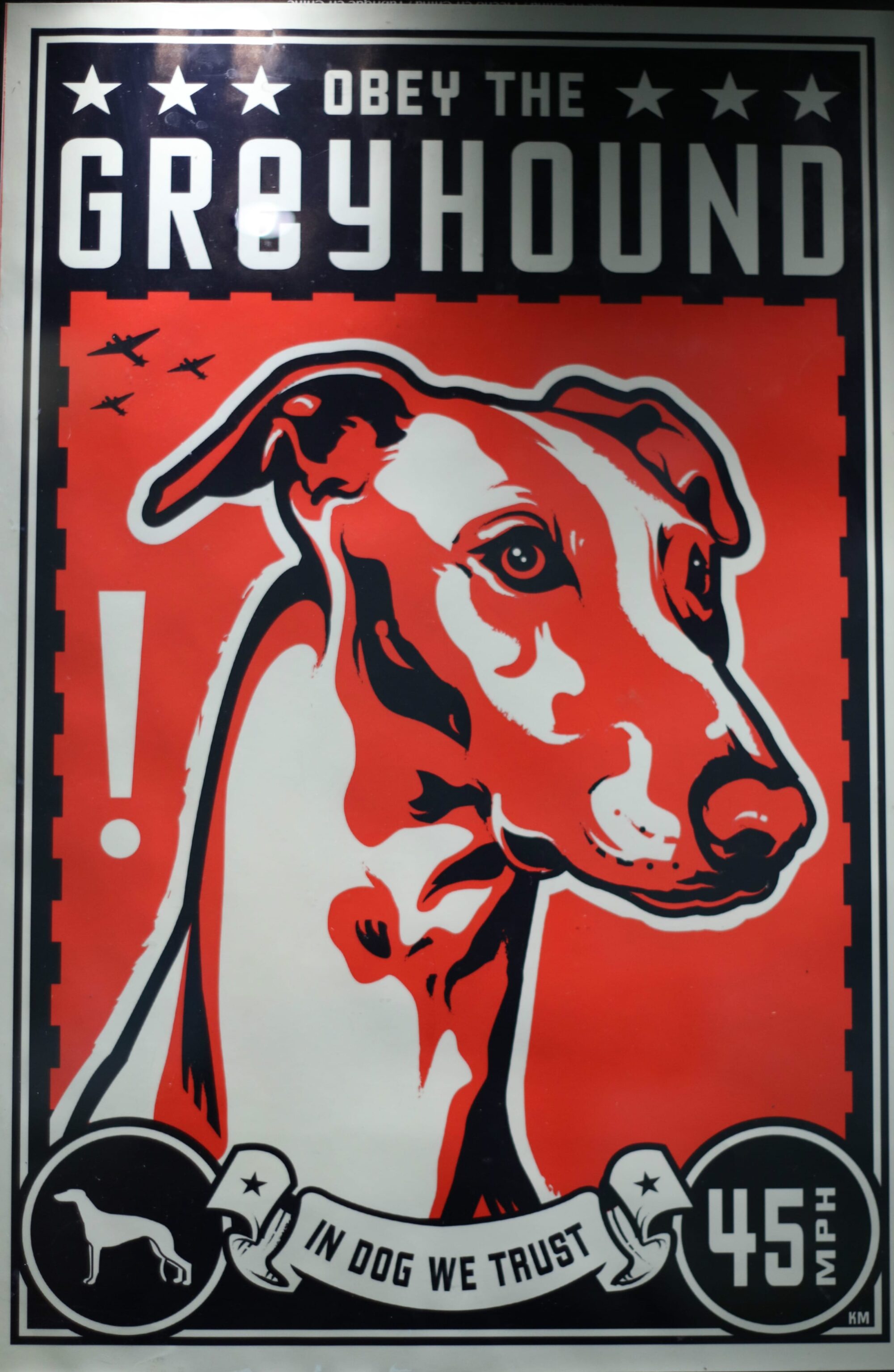 Black, red, and white poster with a stylized image of a greyhound's head and neck in semi-profile. Text reads Obey the Greyhound, in dog we trust, 45 mph.