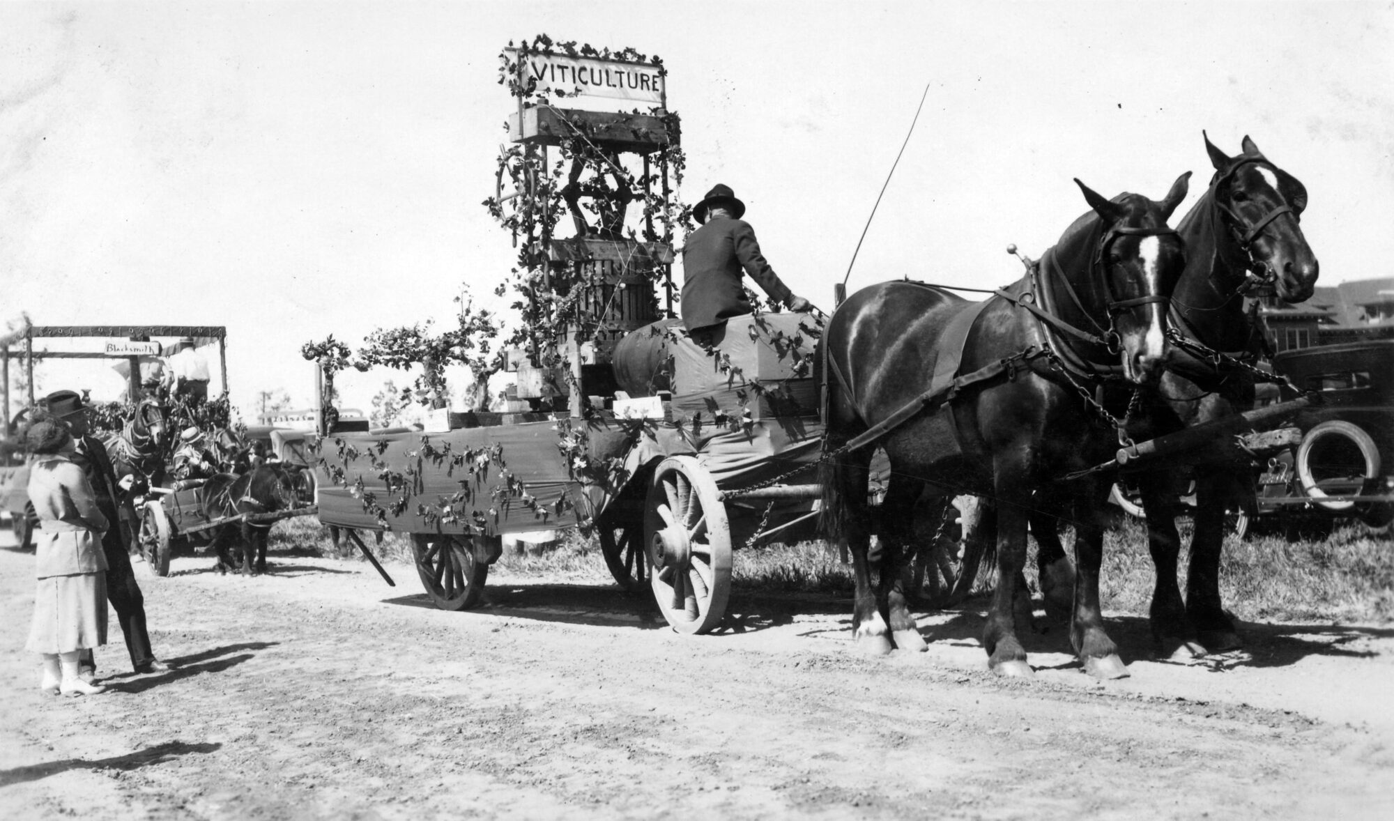Wagon-based float wrapped in vines being pulled by horses
