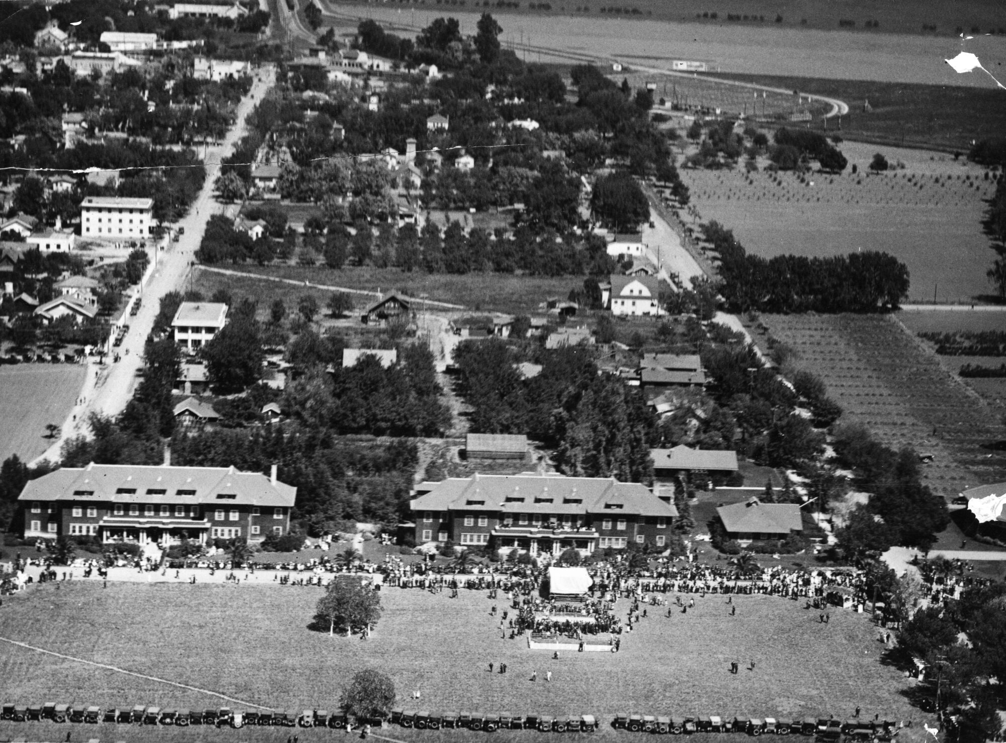 Aerial view of campus buildings, fields, and many Picnic Day attendees lining the streets
