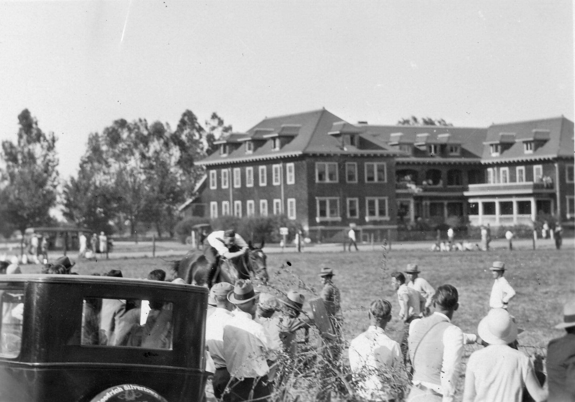 Crowd watching a man on a horse go by