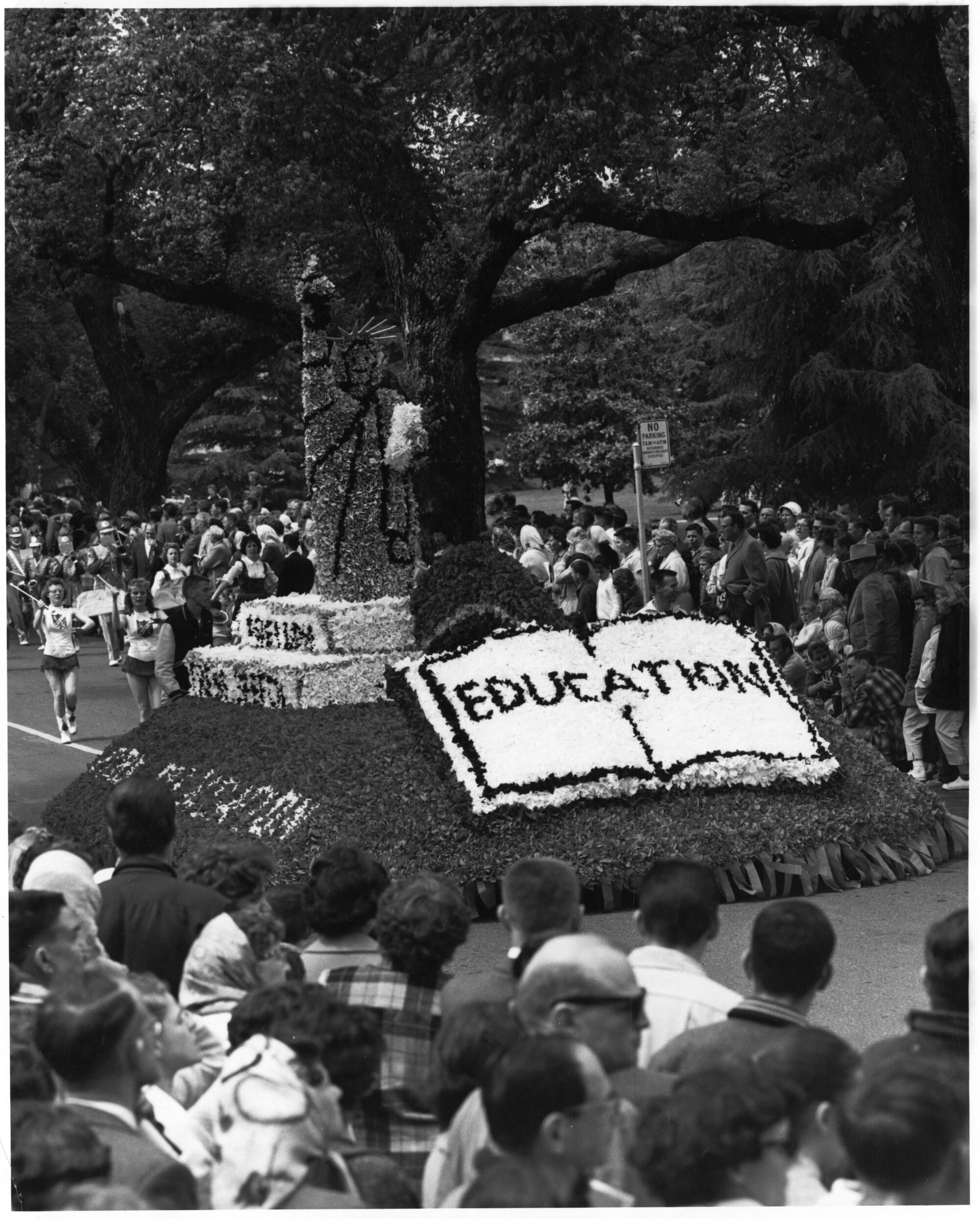 Float of the statue of liberty with open book labeled education