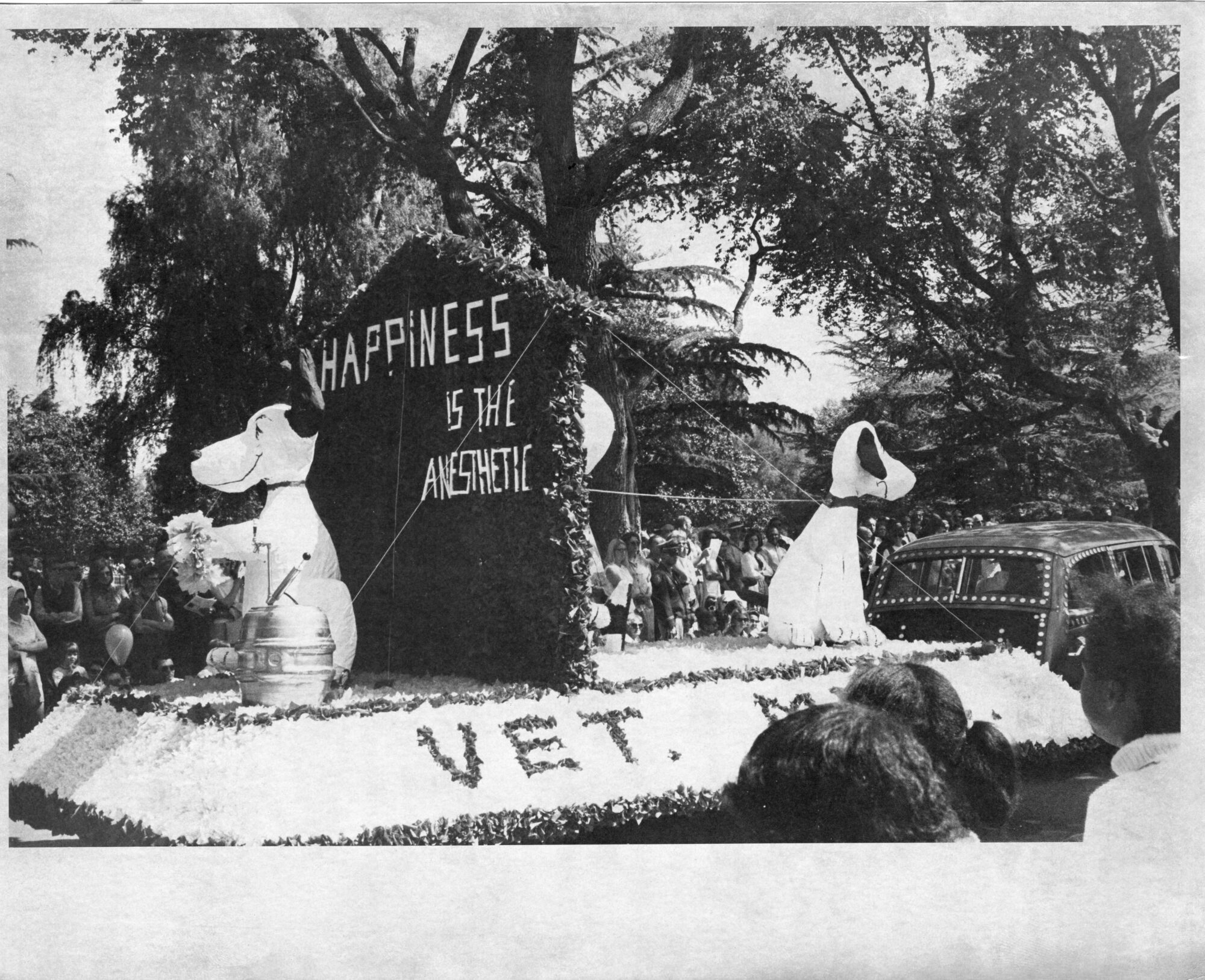 Float with two blow-up Snoopie dogs labeled "Happiness is the anesthetic"