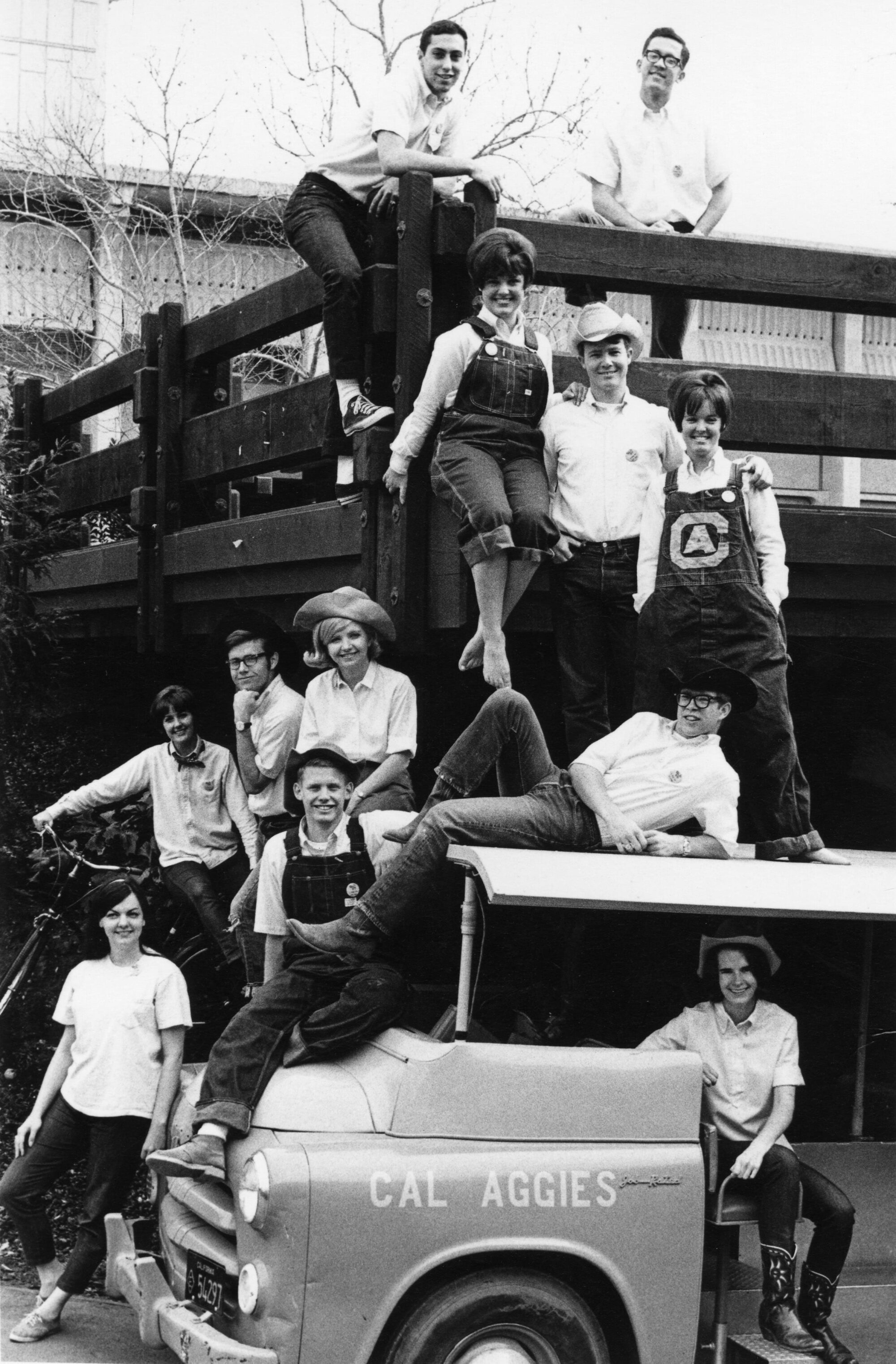 Group of Picnic Day organizers posing around and inside a parked vehicle on campus.