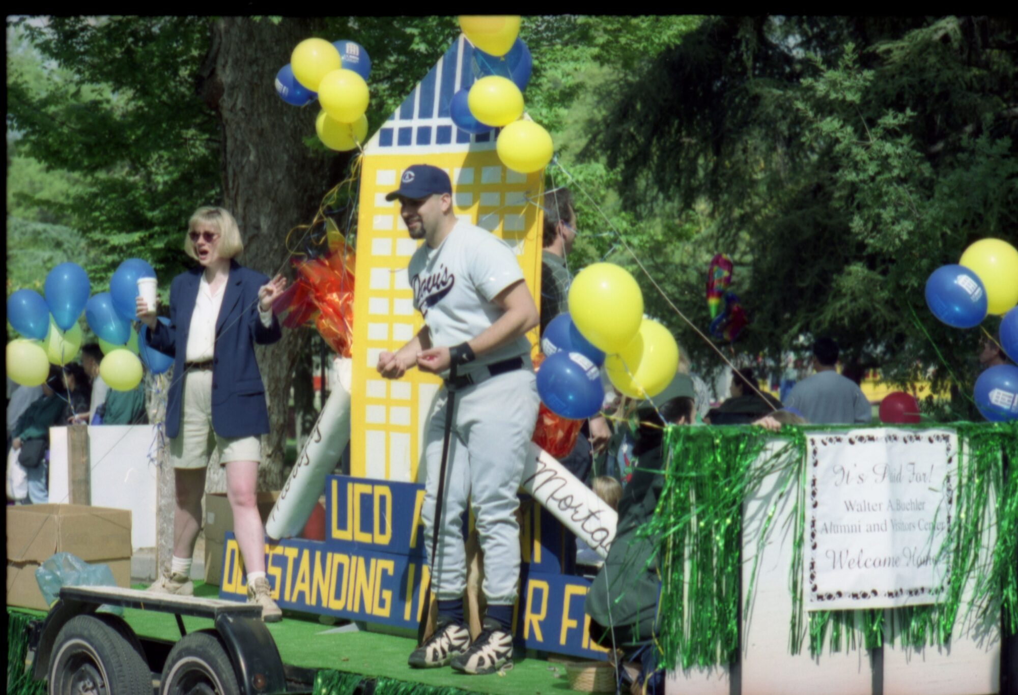 Float with appear skyscraper ridden by a women in a short jacket and man in baseball uniform