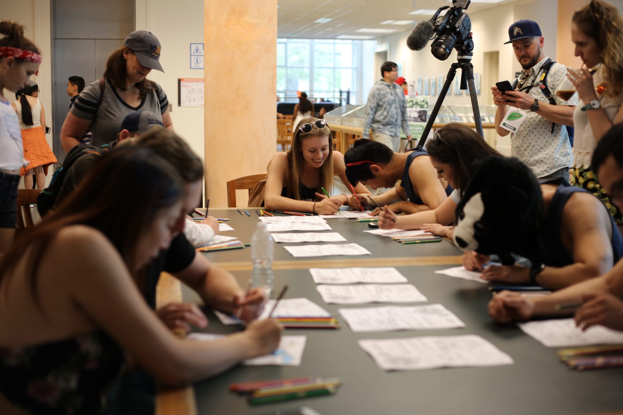 Smiling people coloring pages at a long table