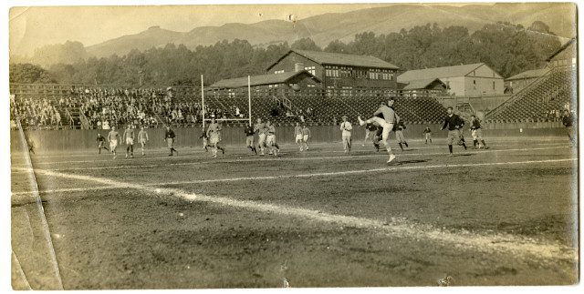 A black and white photograph of a rugby game in session.