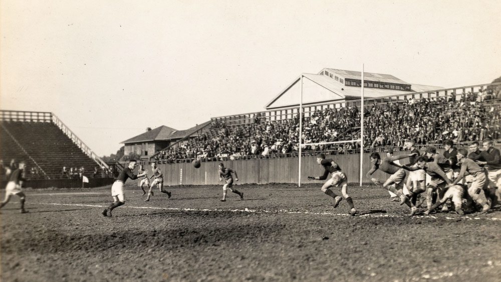 A black and white photograph of a rugby game in session.
