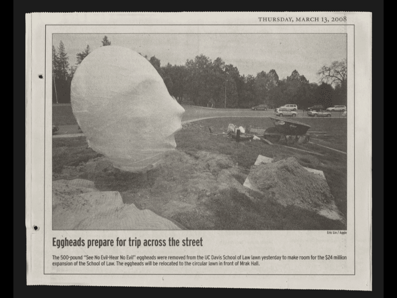 Newspaper clipping with a captioned photo of an upright Egghead surrounded by construction-area dirt piles and a wheelbarrow.