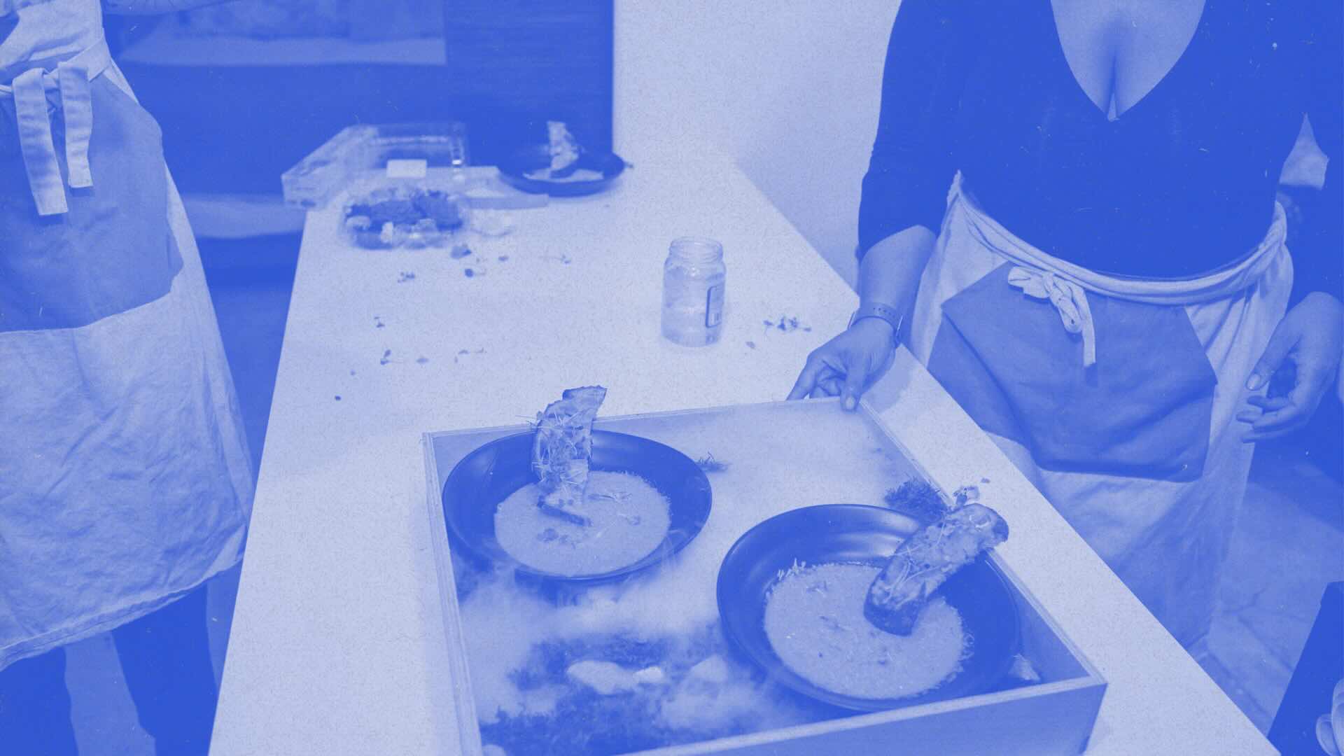 Nia Lee, Black Food Futurist, preparing a culinary dish. Image in bright blue duotone.