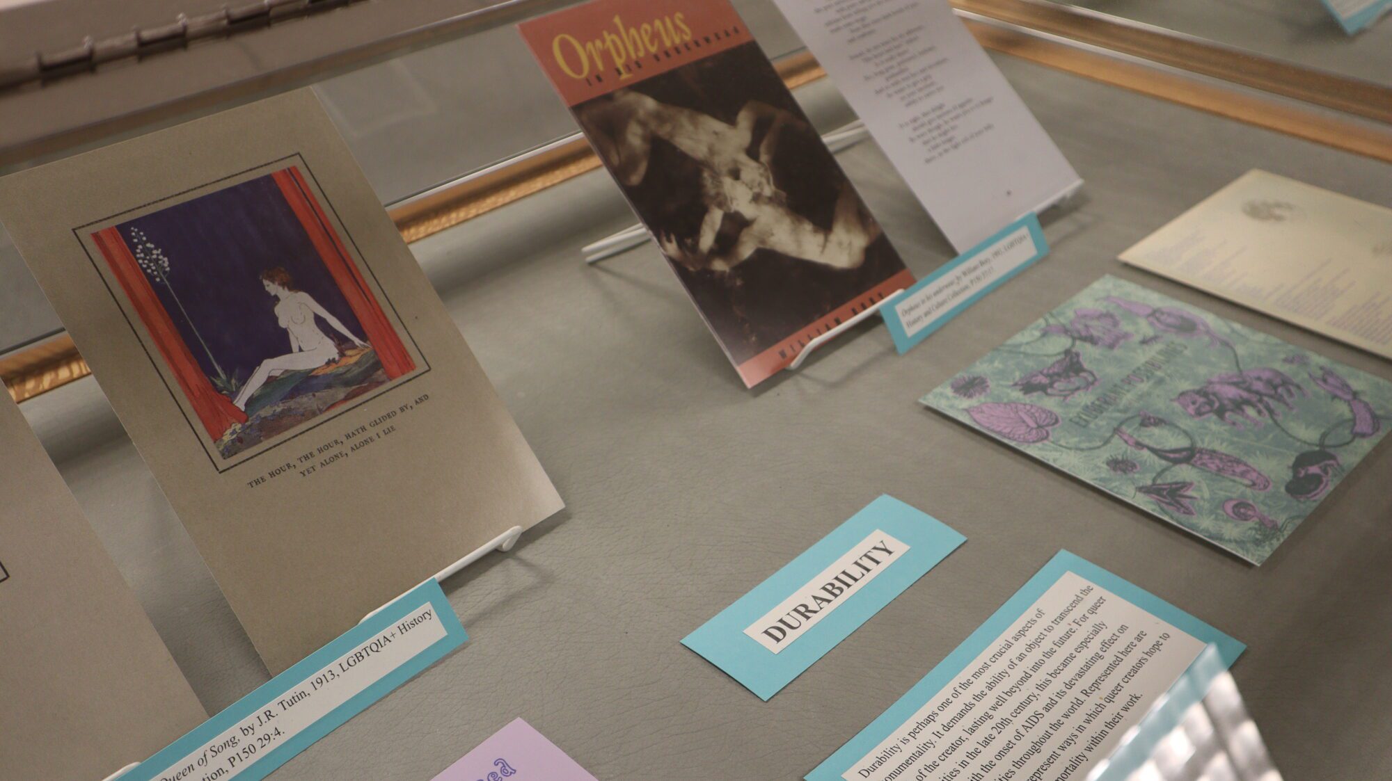 A display case filled with facsimiles of book covers and poetry.