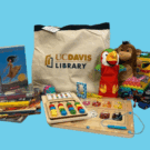 Activity kit bag with UC Davis Library logo, puzzles, books and finger puppets