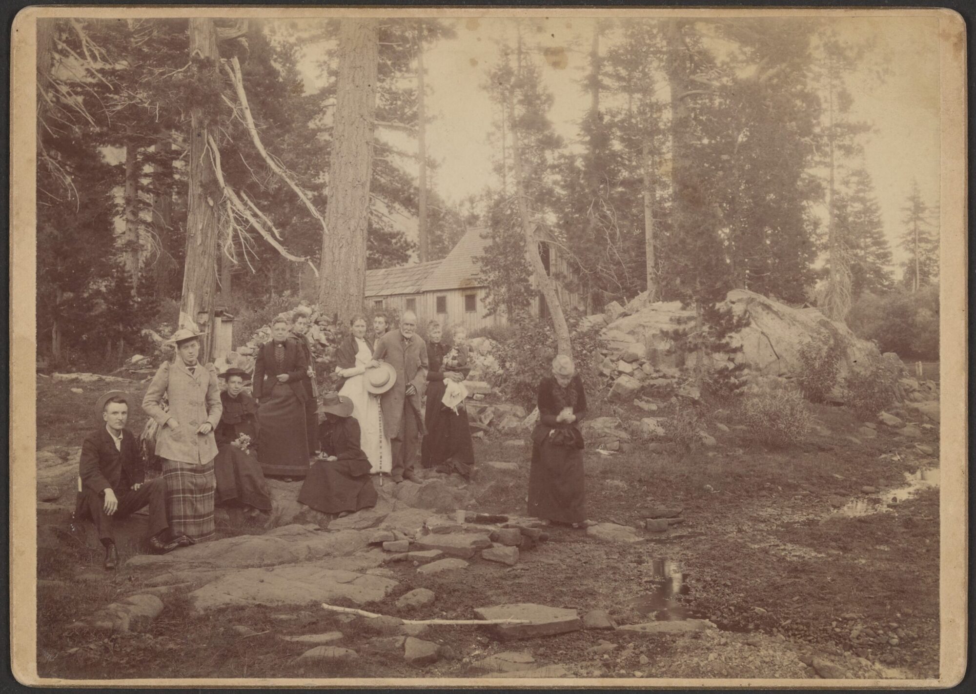 A black and white photograph of various people identified as the Gilmore family in the woods.