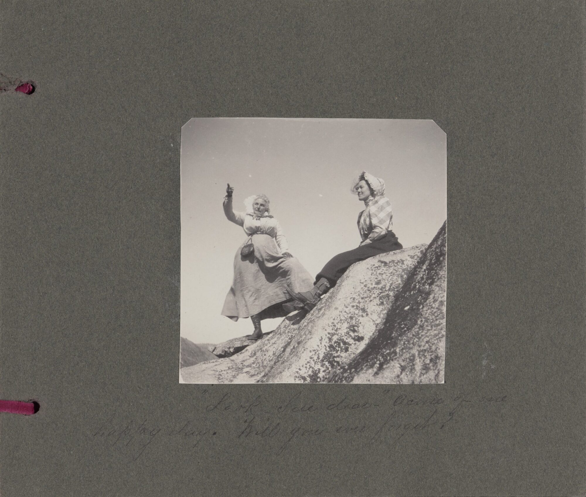 A black and white photograph of a two women sitting on a mountain.