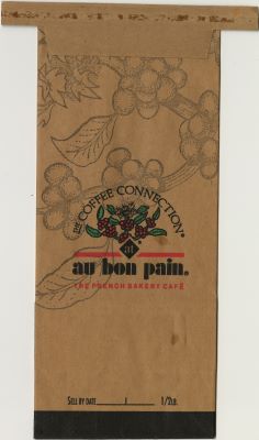 A brown coffee bag with faintly printed coffee berries in the background. The words “Coffee Connection®” appear above colored coffee berries and the words “at Au Bon Pain: The French Bakery Cafe.” An empty “Sell by date” section appears at the bottom of the bag.