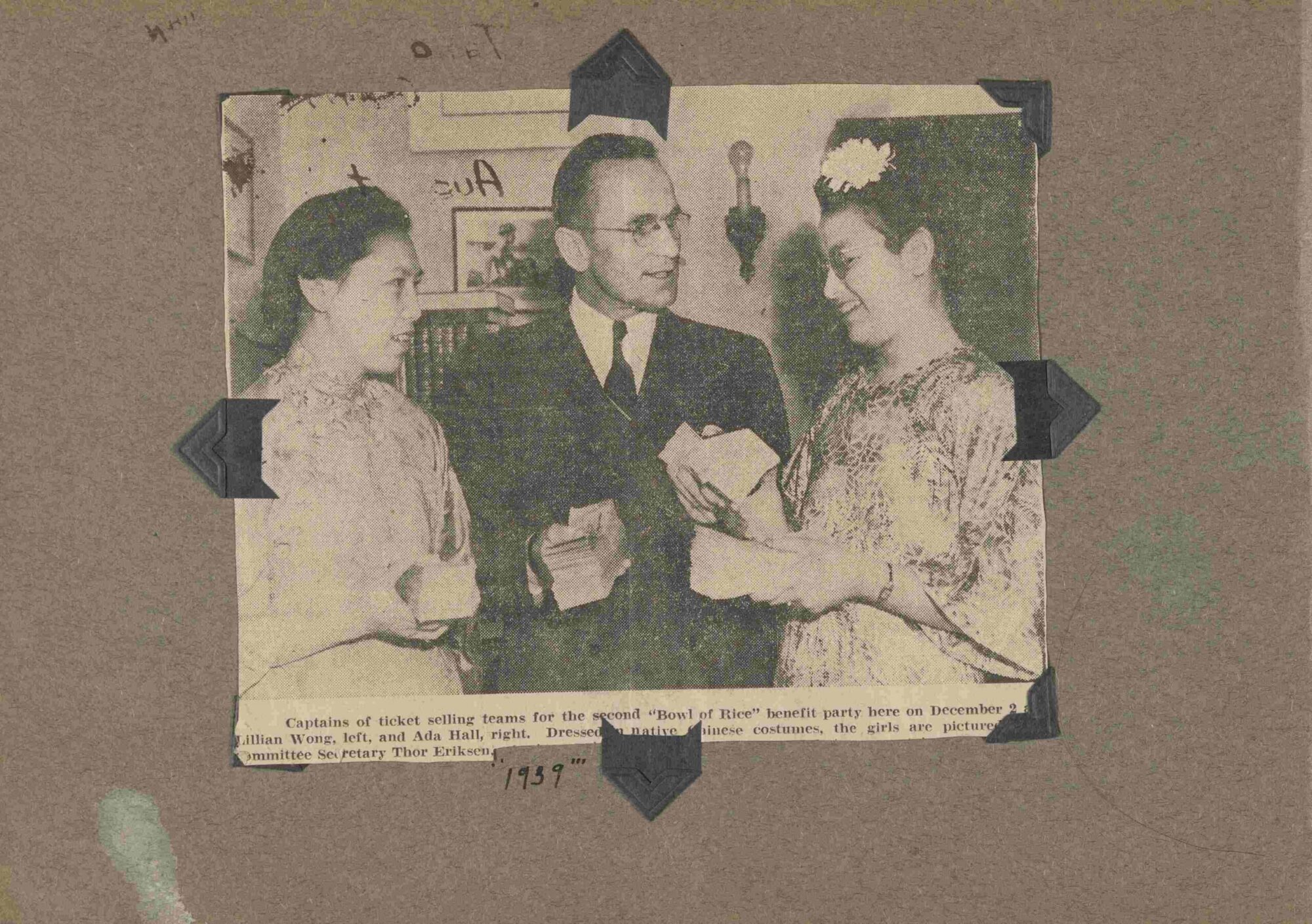 A newspaper clipping containing a photograph of three people at a benefit party.