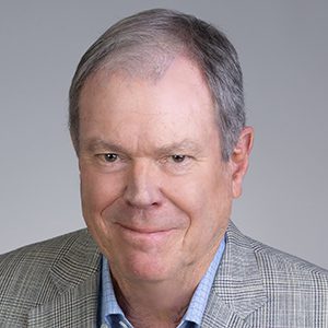 A headshot of an older man smiling at the camera.