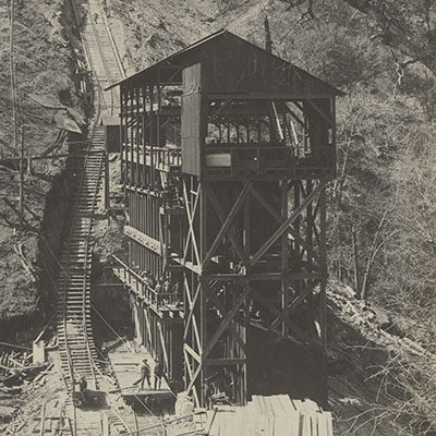 A black and white photograph of a wooden mining structure.