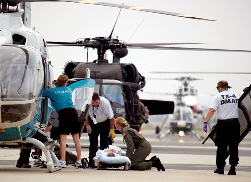 A disaster response team loading a patient onto a helicopter in New Orleans after Hurricane Katrina