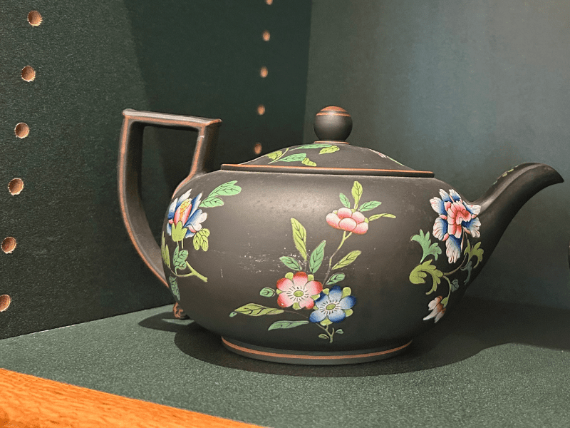 black stoneware teapot with floral pattern.